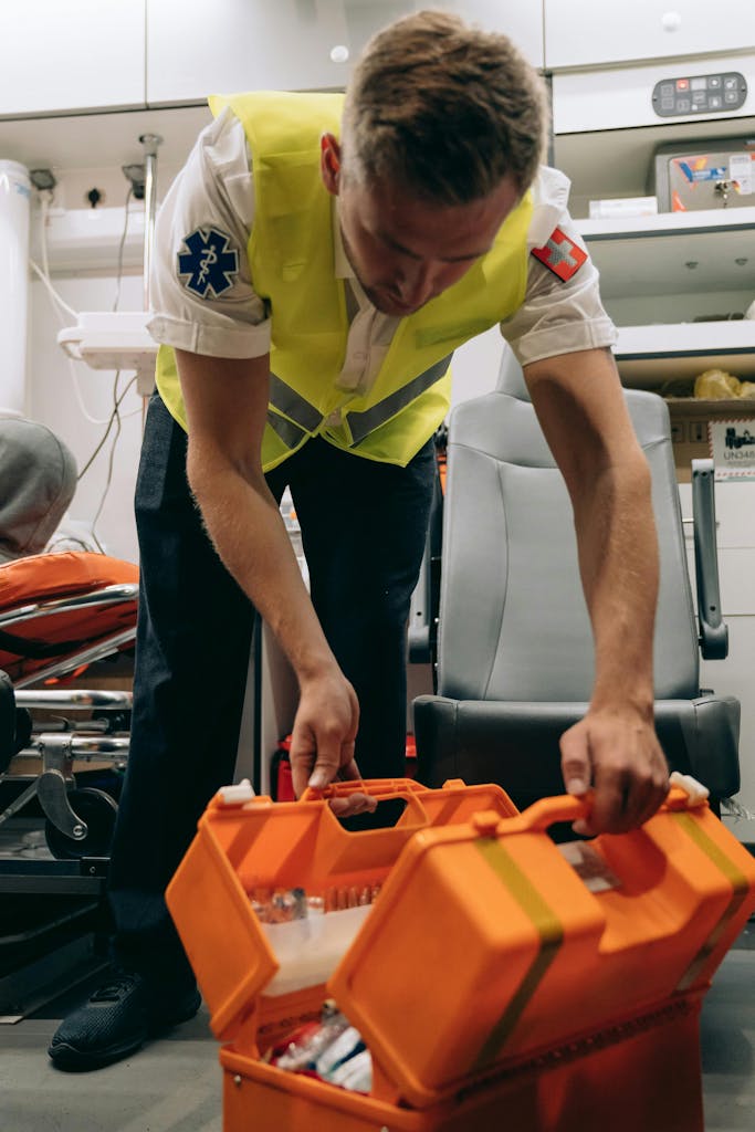 Paramedic arranging equipment inside an ambulance, ensuring readiness for emergencies.